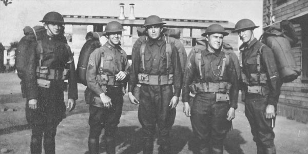 Men in uniforms wearing helmets and backpacks.