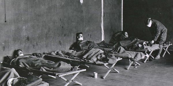 Men in cots with masks over their noses and mouths.