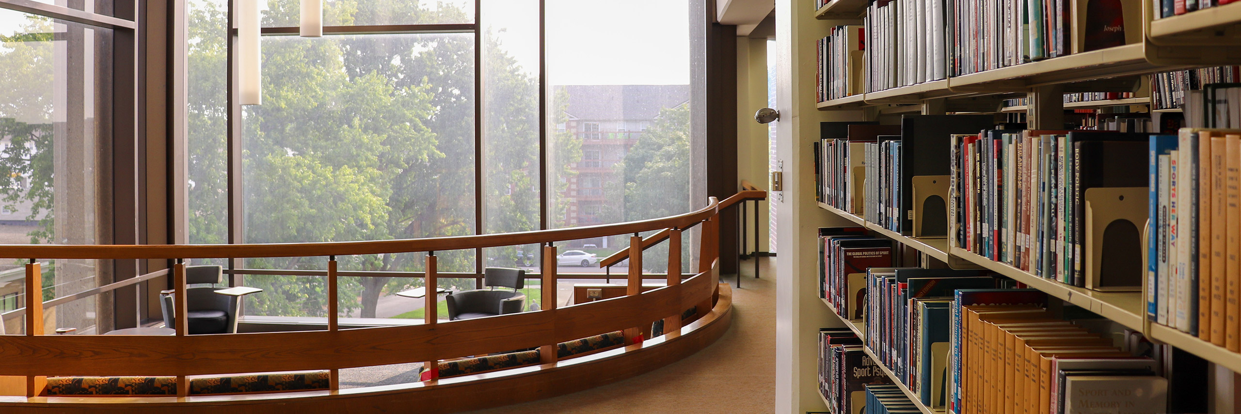 An interior view of Milner Library reveals rows of bookshelves filled with a diverse collection of books.