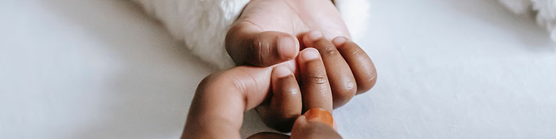 Woman holding hands with baby.