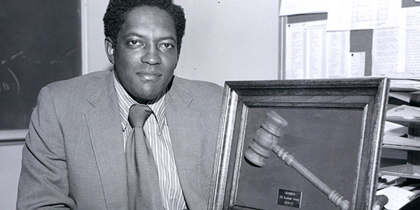 photo of a man sitting next to a mounted gavel