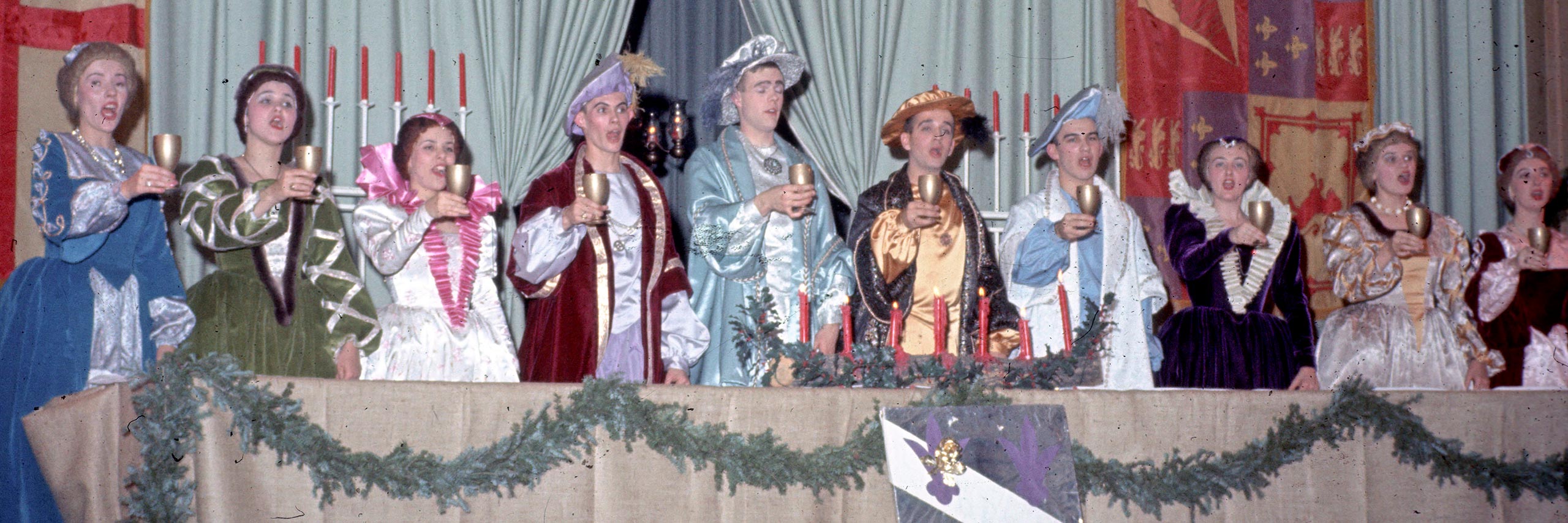 People in madrigal costumes giving a toast