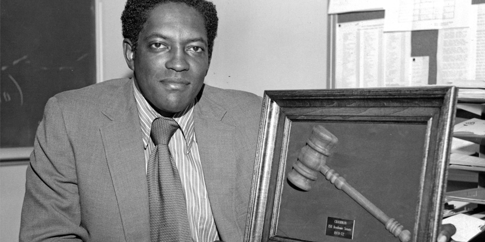 Photograph of a man holding a mounted gavel