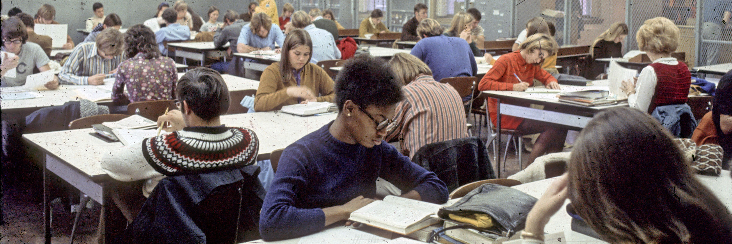 students sitting at desks reading and studying
