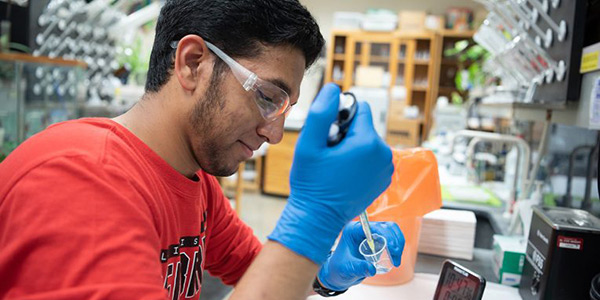 A student using a pipette in a lab