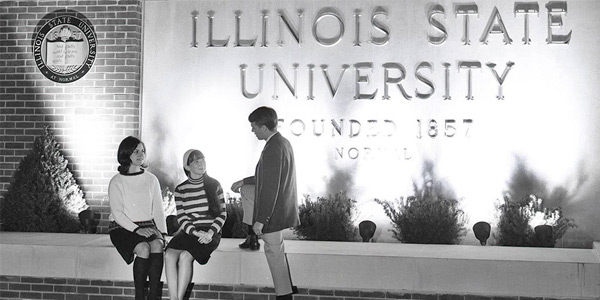 3 people in front of a lit Illinois State University sign