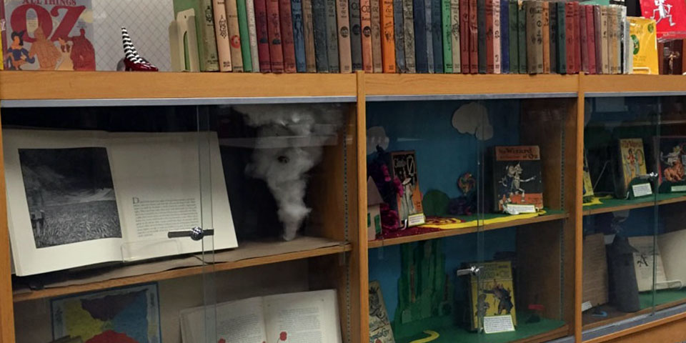 Shelves with Wizard of Oz books and related materials