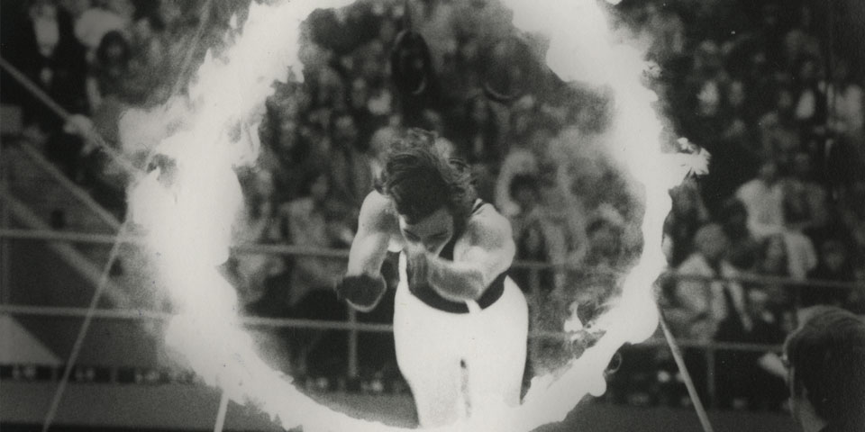 Gamma Phi member jumping through a ring of fire.