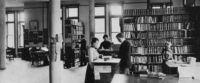 A black and white vintage photo of students in a library.